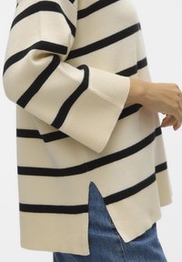 Maglione beige a righe con strisce orizzontali nere, polsini a coste e spacchi laterali. Tessuto morbido, vestibilità rilassata e design casual.