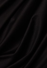 Gładka czarna tkanina z miękkimi fałdami i subtelnym połyskiem, tworząca delikatne fale.