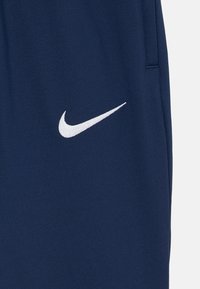Námornícke športové šortky vyrobené z mäkkej tkaniny, so bielym vyšitým logom Nike na ľavej strane a bočnou kapsou.