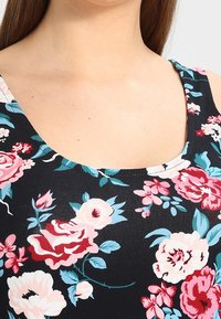 Débardeur noir à motifs floraux avec un décolleté en forme de scoop, des motifs de roses roses et bleues vifs, et une texture de tissu doux et extensible.