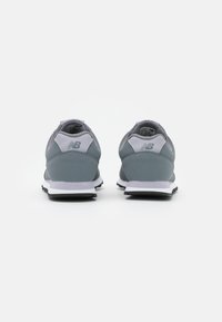 Le scarpe da corsa grigie presentano un materiale liscio con dettagli in rete, una suola intermedia bianca e una suola nera. Il design include un logo sul tallone.