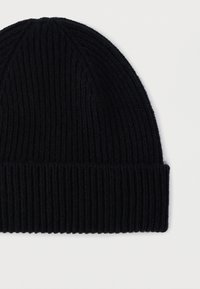 Gorro de malha canelada preto com bainha dobrada, sobre um fundo branco liso.