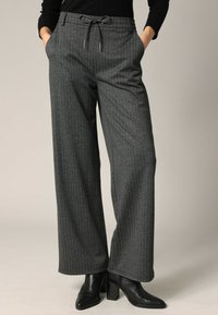 Grijze gestreepte broek met een relaxte pasvorm, elastische taille met trekkoord en zijzakken. Gemaakt van een gestructureerde stof.