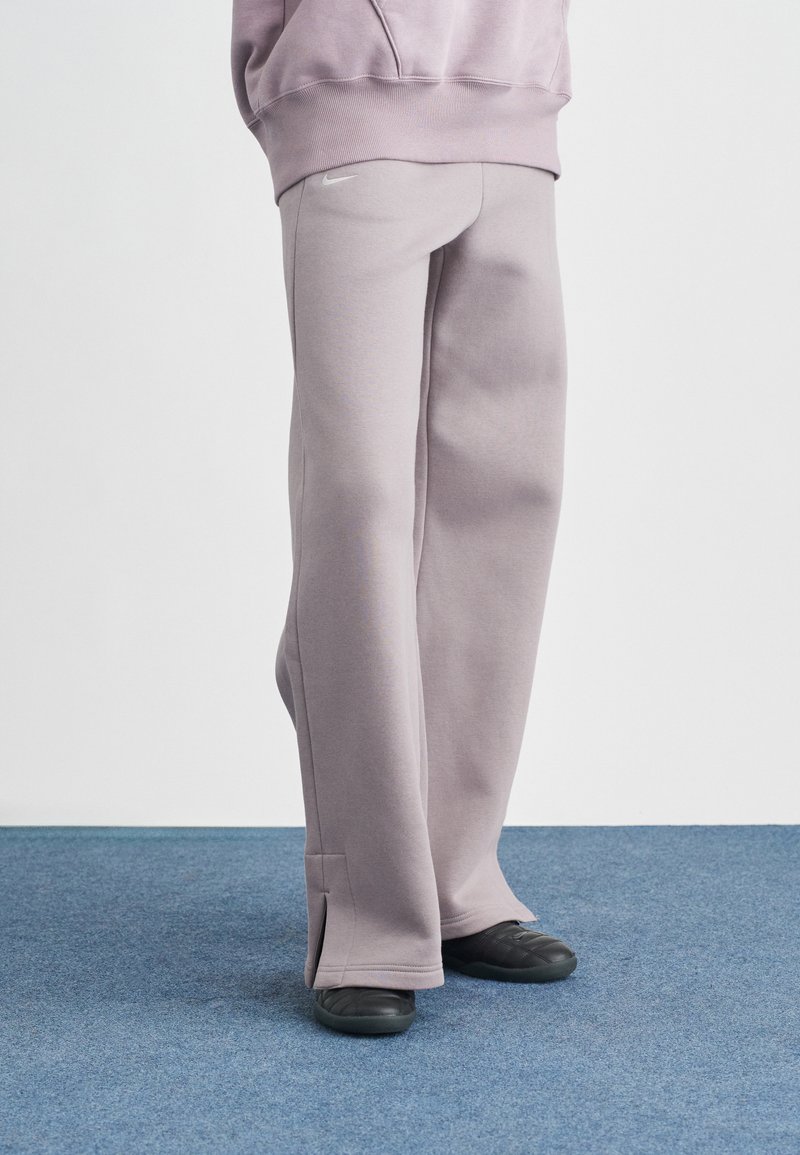 Ανοιχτό μοβ φόρμα από μαλακό ύφασμα, με άνετη εφαρμογή, ραφές διακοσμητικές και ανοίγματα στο πλάι στους αστραγάλους.