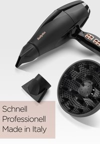 Czarna suszarka do włosów BaByliss z dwoma czarnymi końcówkami na białej powierzchni oraz tekstem „Schnell Professionell Made in Italy.”