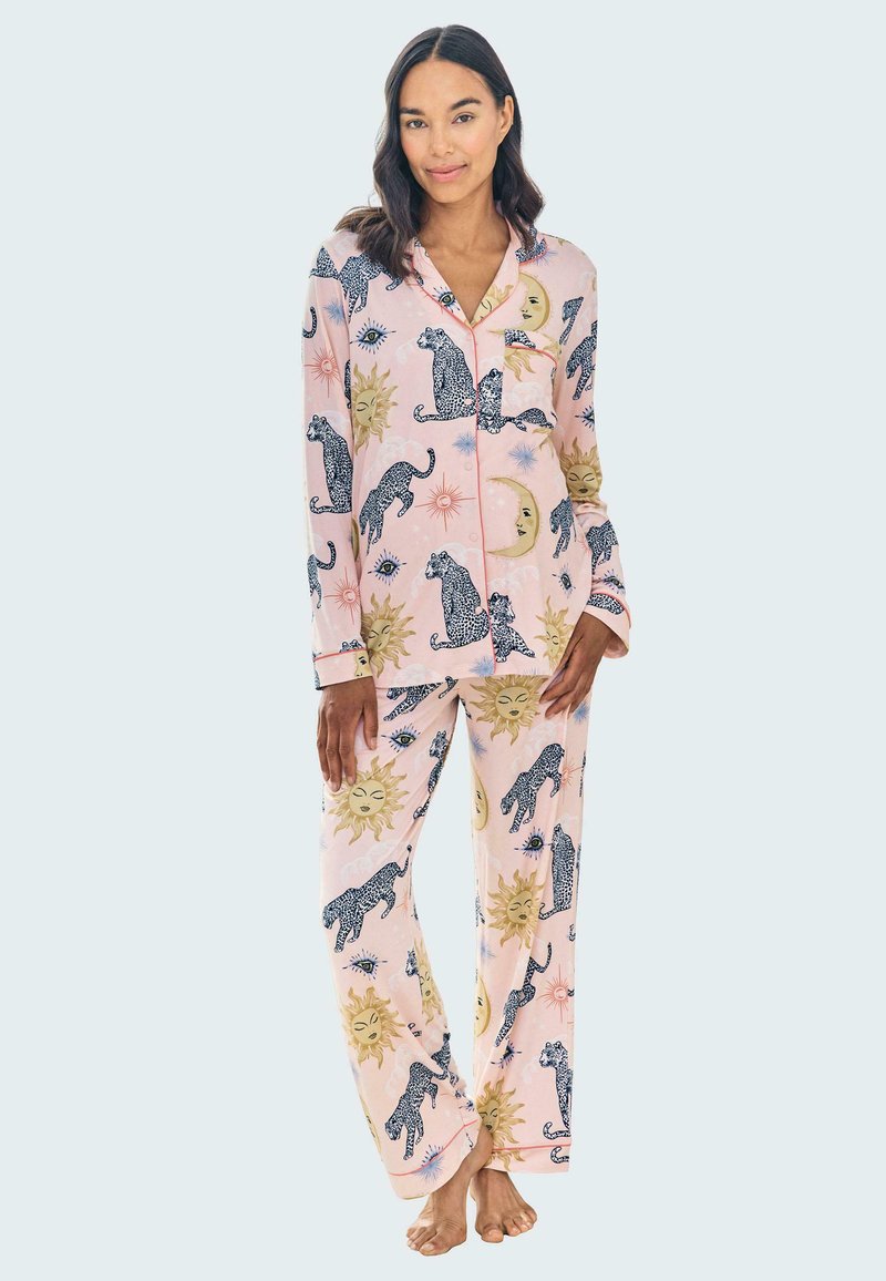 Rosa pyjamaset med svarta och gyllene leopardmönster, soler och himmelska design. Tillverkat av mjukt tyg med en knäppskjorta och matchande byxor.