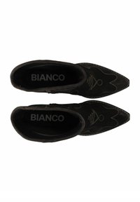 Bottines en daim noir à bout pointu, avec des coutures décoratives et un design de tige incurvée. À l'intérieur, "BIANCO" est visible.