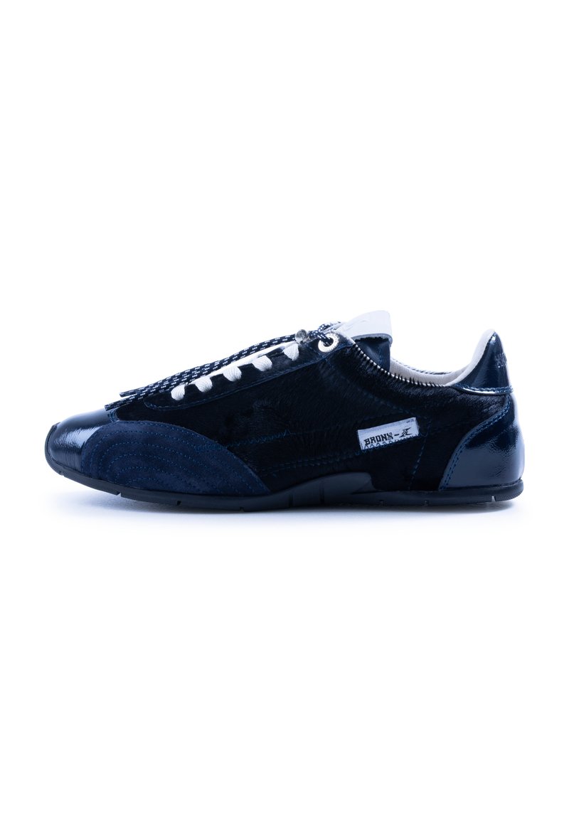 Zapatilla azul que presenta una mezcla de materiales brillantes y texturizados, con cordones blancos en contraste y un diseño elegante de perfil bajo.