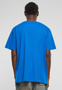 Blå bomulds T-shirt med en afslappet pasform og korte ærmer, har en rund halsudskæring og lige kant, enkel ensfarvet design.