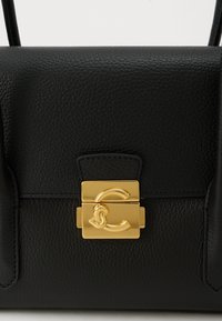 Borsa nera in pelle con superficie strutturata e chiusura rettangolare dorata con un motivo intrecciato a forma di "C".