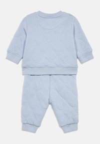 Μπλε φωτεινής απόχρωσης μακριά μανίκια μωρουδιακή στολή με ραφιέρα και τελειώματα, που περιλαμβάνει ένα μπλουζάκι και το αντίστοιχο παντελόνι, απεικονισμένη από πίσω.