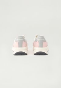 New Balance-sneakers med en rosa semsket overdel og hvit tekstil, grå detaljer og en beige mellomsåle. Har en teksturert gummisåle.
