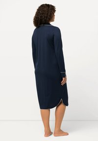 Camicia da notte blu navy a maniche lunghe con piping bianco, tessuto liscio e orlo arrotondato, caratterizzata da un colletto classico e lunghezza fino al polpaccio.