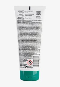 Tube blanc de 200 ml avec bouchon vert, présentant du texte et des symboles noirs. Le texte inclut les détails du produit et les informations de sécurité, avec un code QR.