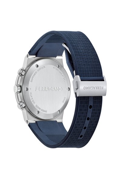 Silver stainless steel watch with a navy blue rubber strap, featuring a textured pattern, and a brushed metal case back.