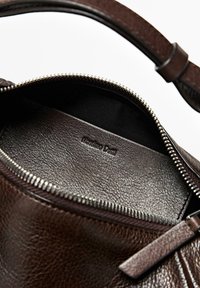 Tmavě hnědá kožená taška s otevřeným zipem odhalujícím koženou vnitřní kapsu se stejným odstínem, na které je vyražené logo „Massimo Dutti“.