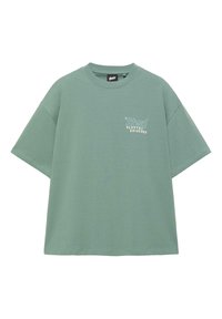 Tricou oversize verde salvie cu mâneci scurte, guler rotund și text alb „Stwd Playful Universe” pe partea stângă a pieptului.