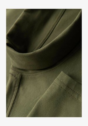 Olivgrüner Pullover mit hohem Kragen, aus weichem Stoff gefertigt. Verfügt über sichtbare Nähte und ein kleines Taschendetail.