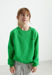 Felpa verde con texture a costine, colletto rotondo e spalle ribassate. Presenta un piccolo logo nero sul petto e una vestibilità ampia.