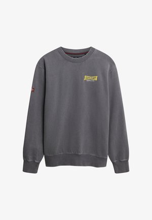 Ciemnoszara bluza z okrągłym dekoltem, długimi rękawami, prążkowanymi mankietami i żółtym logo "Superdry Supply Co." na klatce piersiowej.