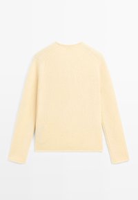 Maglione beige lavorato a maglia con maniche lunghe, scollatura tonda e dettagli a costine sui polsini e sull'orlo. Texture morbida con una vestibilità comoda.