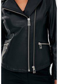 Zwarte leren motorjack met een gekartelde kraag, meerdere ritsen en verticale geribbelde details op de schouders.