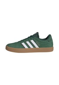 Zielony sneaker Adidas z białymi paskami, gumową podeszwą i sznurowanym wzorem, widoczny z profilu na białym tle.