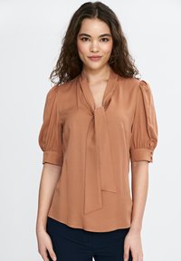 Brązowa, lekka bluzka z wiązanym dekoltem, krótkimi bufkami i zapięciem na guziki. Gładka tekstura i zwiewny fason.