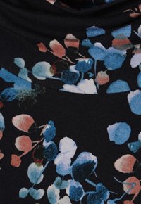 Schwarzer Stoff mit floralem Muster, das blaue, rosa und weiße Blüten zeigt. Weiche Textur mit einem lockeren, fallenden Design am Halsausschnitt.