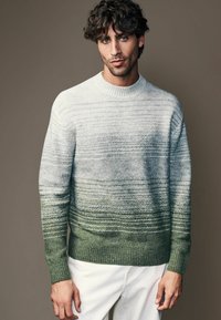 Suéter de punto ligero con un diseño en degradado que va de gris claro a verde, con patrones de rayas horizontales y puños y dobladillo acanalados.