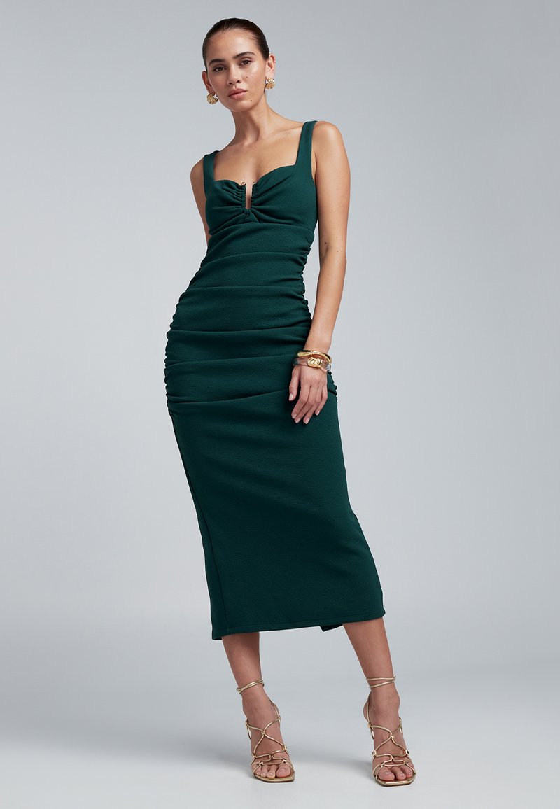 Dark green, fitted midi dress with a sweetheart neckline and gathered texture. Features a front keyhole detail and thick shoulder straps.