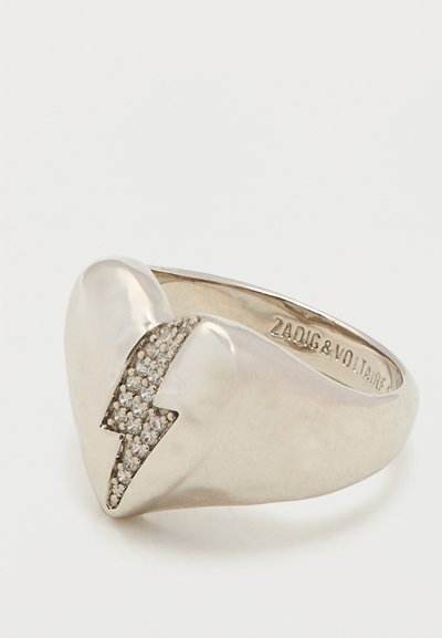 Zilveren ring met een hartvorm gesplitst door een bliksemschichtontwerp, versierd met kleine heldere edelstenen, gegraveerd met Zadig & Voltaire.
