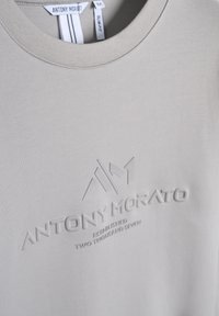 Camiseta de algodón gris claro con cuello redondo, corte ajustado y logo en relieve con los detalles "ANTONY MORATO" y "ESTABLISHED 2007".