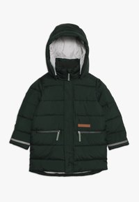 Giacca imbottita verde scuro con cappuccio staccabile, tasche con zip, dettagli grigi e superficie texturizzata. Presenta una patch in pelle con logo.