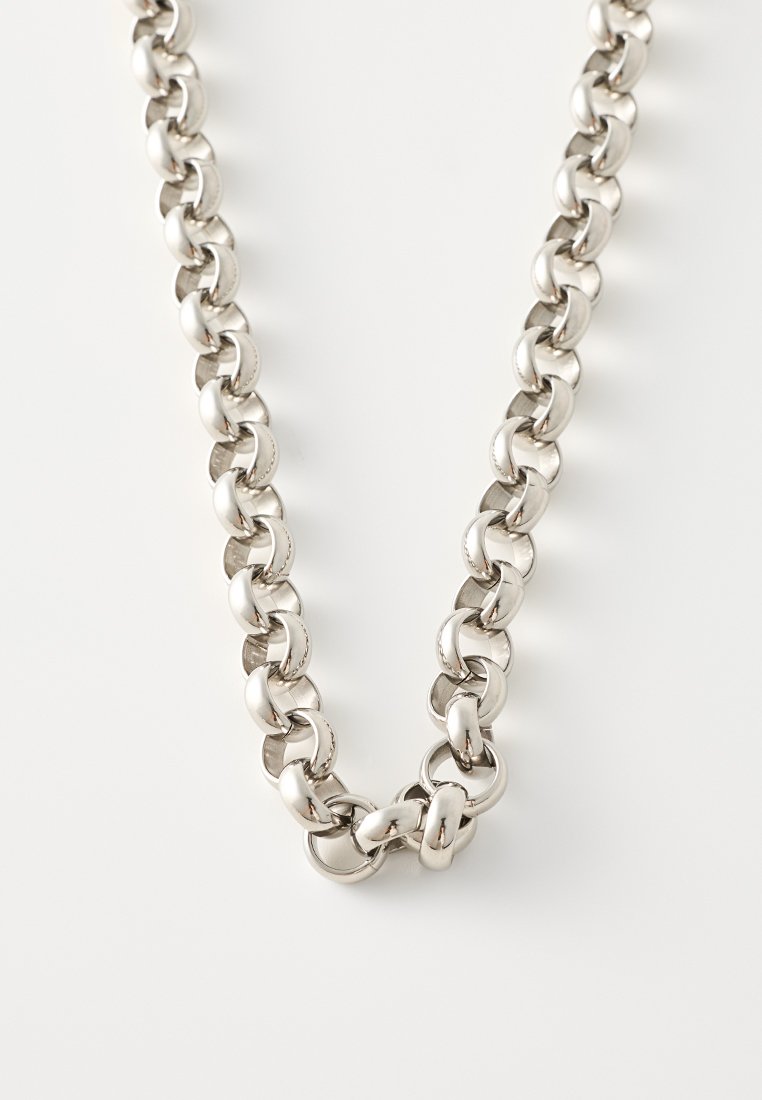 Collana in metallo argento con catena composta da anelli ovali interconnessi, caratterizzata da una finitura liscia e lucida e spazi tra gli anelli regolari e uniformi.