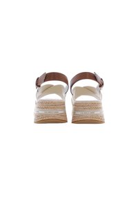 Hnědé páskové sandály s platformou vyrobenou z pleteného jutového vlákna a bílou texturovanou podrážkou. Nastavitelné přezkové zapínání na zadní straně.