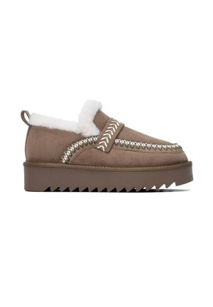 Zapato marrón de ante sin cordones con forro blanco de piel de oveja, costuras decorativas y suela gruesa ranurada, visto de lado.