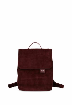 Dunkelroter Cord-Rucksack mit Überschlagverschluss und kleinem Stoff-Logoanhänger vorne, zentriert auf weißem Hintergrund.