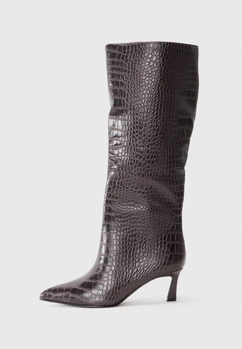 Bottes montantes en simili cuir marron avec un motif crocodile, bout pointu et un petit talon empilé. Texture lisse, design élégant.