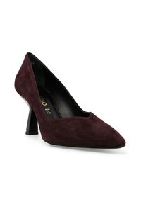 Scarpa con tacco alto in suede bordeaux, dalla punta affusolata e tacco a blocco di altezza media. L'interno presenta una fodera nera e una marcatura dorata.