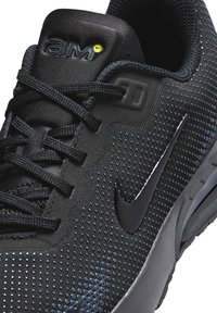 Crne atletske cipele s teksturiranim mrežastim gornjim dijelom, modernim dizajnom, reflektirajućim detaljima i vidljivom Air Max amortizacijskom jedinicom.