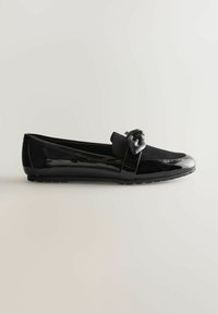 Sorte patenteret lædersandal med en suede detalje, der har en dekorativ sløjfe foran, rund tå og fleksibel gummisål.