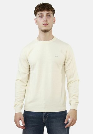 Maglione a maniche lunghe color crema realizzato in un morbido tessuto a maglia. Presenta un collo rotondo e un piccolo logo sul lato sinistro del petto.