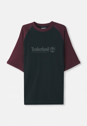 Zwart T-shirt met bordeauxrode raglanmouwen. Voorzien van het "Timberland Highsnobiety" logo in grijs, ronde halslijn en korte mouwen. Gemaakt van een katoenmix.