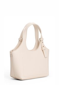 Beżowa skórzana torebka z dwoma zaokrąglonymi uchwytami, kwadratowym korpusem oraz płaską kieszenią po jednej stronie. Gładka faktura i minimalistyczny design.