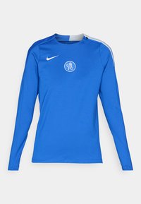 Long-sleeve athletic jersey in bright blue, made of smooth fabric. Features a round neckline, white Nike logo, and FC logo on the chest.
