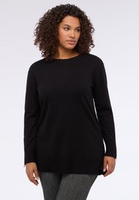 Černý svetr s dlouhým rukávem, ribovaným lemem a manžetami, s kulatým výstřihem. Tkanina vypadá měkce a má zajímavou strukturu.