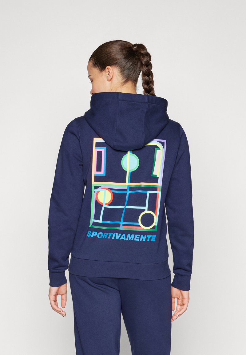 Navy mikina s živým geometrickým vzorom na chrbte, obsahujúcim kruhy a obdĺžniky. Text „SPORTIVAMENTE“ na spodnej strane. Zmes bavlny.