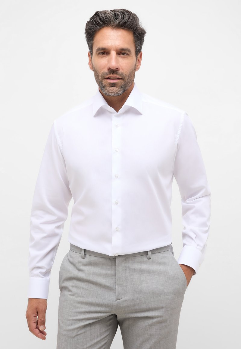 Witte overhemd met lange mouwen en een klassieke kraag, van gladde stof, met knopen aan de voorkant, gecombineerd met lichtgrijze op maat gemaakte broek.