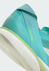 Scarpa da corsa turchese con materiale in rete, tallone rinforzato e suola bianca. Presenta dettagli verdi e il logo "ADIZERO" sul lato.